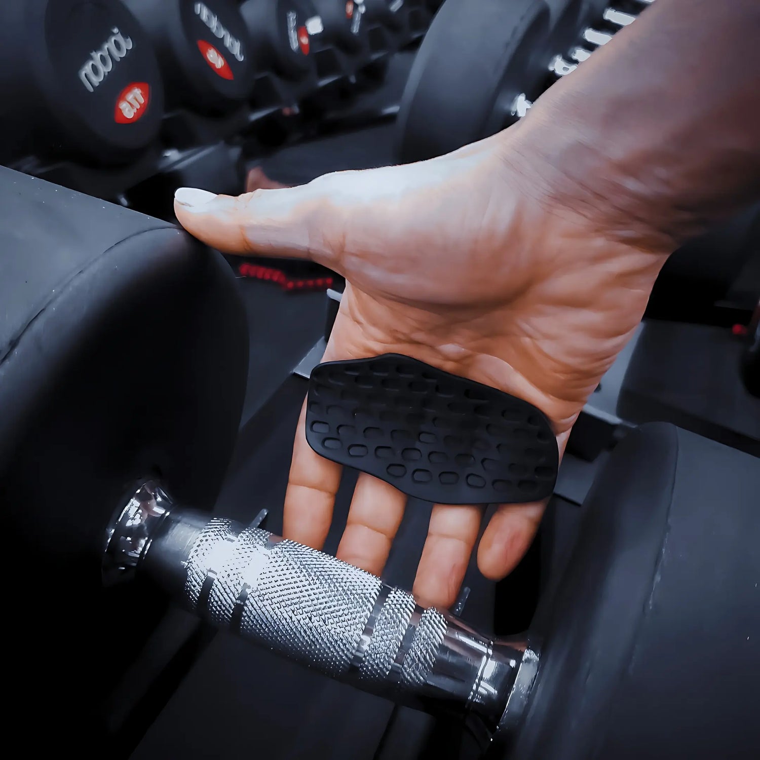 Hand holding OctoGrips workout grip, preventing calluses and improving grip strength.